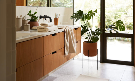 A modern bathroom scene with towels stacked on the countertop