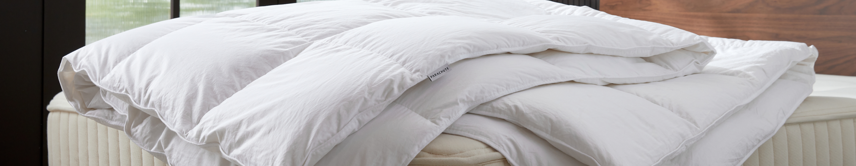 A fluffy white duvet sits atop a mattress 